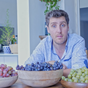 Fabien Moine devant des saladiers de différentes variétés de raisins
